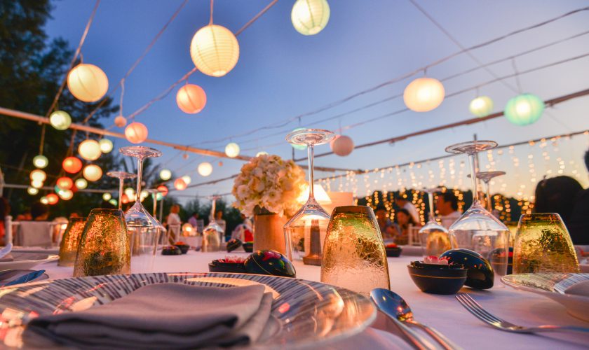 Festlich gedeckte Tafel unter bunten Lampions am Abend